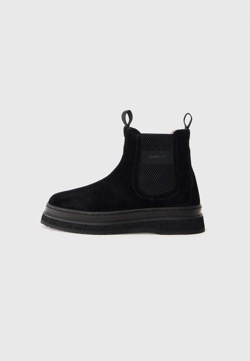 Black suede chelsea boots featuring elastic side panels, pull tabs, and a textured rubber sole. Slightly elevated platform with stitch detailing.