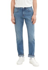Jeans din denim albastru deschis cu o croială dreaptă, având un design clasic cu cinci buzunare și manșete rulate, purtate cu adidași albi.