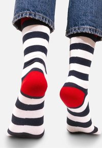 Skarpetki w marynarskie i białe paski z czerwonymi akcentami na pięcie, wykonane z miękkiego materiału, z wygodnym krojem i żebrowanymi mankietami.