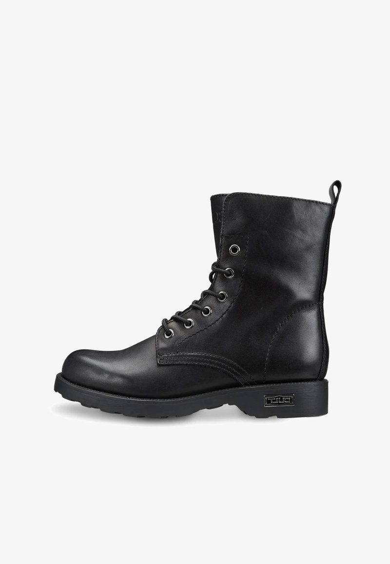 Stivale alla caviglia in pelle nera con punta tonda, lacci, occhielli in metallo, cuciture laterali e suola piatta in gomma, caratterizzato da un piccolo accento metallico sul tallone.