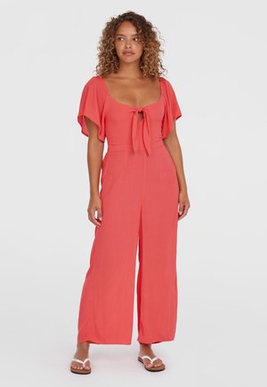 Coral jumpsuit with short flutter sleeves, a front tie detail, and wide-leg pants; made of lightweight fabric for comfort.
