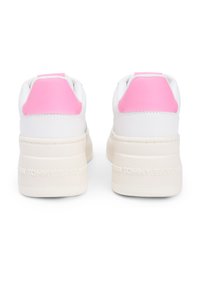 Λευκά αθλητικά παπούτσια με ροζ λεπτομέρειε ς, που διαθέτουν υφή κρεμ σόλας και λογότυπο στη φτέρνα. Σχεδιασμένα με χαμηλό προφίλ και λείες επιφάνειες.