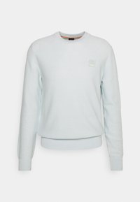 Hellblaues Crewneck-Sweatshirt aus strukturiertem Stoff. Mit gerippten Bündchen und Saum, sowie einem kleinen, geprägten Logo-Patch auf der Brust.