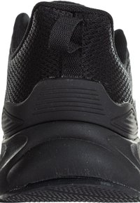 Svart atletisk sko med ett texturerat mesh-övre, gummihäl och ett dragband bak. Designen har strömlinjeformade linjer och en solid sula.