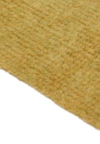 Struktureret gult stof med en blød, fuzzy overflade og subtile farvevariationer, der viser en varm, organisk følelse.