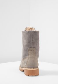 Stivaletto in suede grigio con una morbida fodera interna, suola in gomma piatta, cuciture a contrasto e un tacco distintivo. La vista posteriore mostra una finitura liscia.