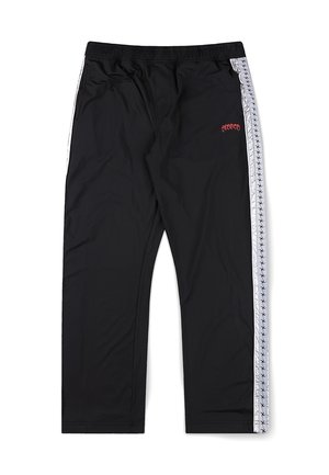 Crne sportske hlače s bijelim bočnim prugama koje imaju mali uzorak ponavljajućeg logotipa i crveni izvezeni tekst na lijevom bedrima.