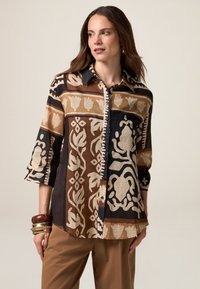 Button-up-Hemd aus braunem und schwarzem Stoff mit cremefarbenen abstrakten Blumen- und geometrischen Mustern, 3/4-Ärmeln und einem Kragen.