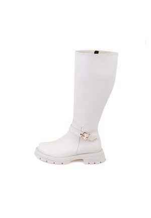 Bottines blanches montant jusqu'au genou, en matériau lisse, avec un détail de boucle sur le côté et une semelle épaisse et texturée pour une meilleure adhérence.