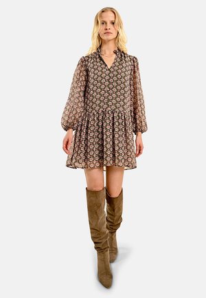 Abito floreale con maniche lunghe e puff, scollatura a v e gonna svasata. Indossato con stivaletti in suede marrone chiaro fino al ginocchio.