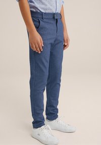 Blå strukturerade byxor med skräddarsydd passform, midjeband med bältesloopar, sidofickor, tillsammans med vita sneakers.