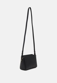 Sort crossbody taske lavet af glat læder med en struktureret form. Har en lang justerbar rem og minimalistiske detaljer i guld.