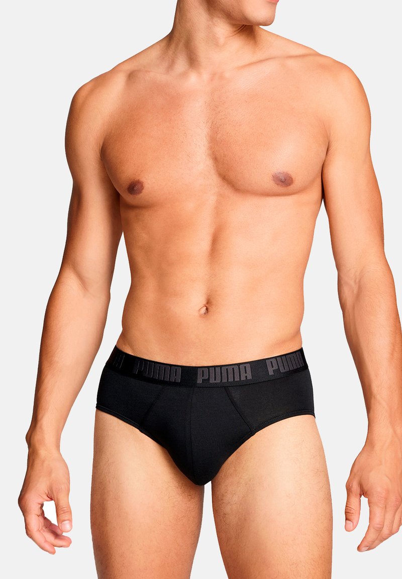 Schwarze Unterhose im Slip-Style aus weichem Stoff, mit einem breiten schwarzen Bund, auf dem "PUMA" in Grau aufgedruckt ist.