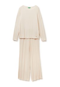 Krémový top s dlouhým rukávem a krajkovým výstřihem, kombinovaný s volnými kalhotami. Měkká, lehká tkanina s jemným texturovaným vzorem.