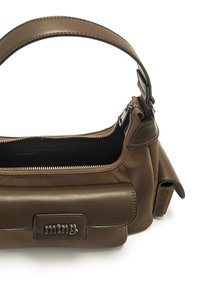 Sac à main en cuir marron avec un design structuré, une fermeture à glissière et une plaque de logo bien visible. Comprend une bandoulière rembourrée.
