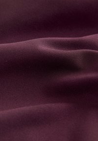 Tessuto color bordeaux intenso con una texture liscia e leggermente lucida, che presenta leggere increspature e una trama fine e uniforme. Nessun motivo o accento visibile.