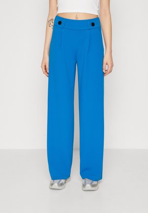 Wijde broek in felblauwe stof met een getailleerd ontwerp, voorzien van twee zwarte knopen op de tailleband en zijplooien.