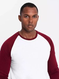 Herren-Raglan-T-Shirt mit weißem Körper und bordeauxroten Ärmeln. Weicher Stoff, runder Halsausschnitt, enganliegende Silhouette. Keine sichtbaren Muster oder Akzente.