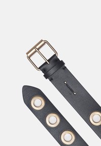 Cinturón de cuero negro con hebilla de latón, que presenta tres acentos metálicos circulares con un diseño texturizado. Textura suave, extremo afilado.