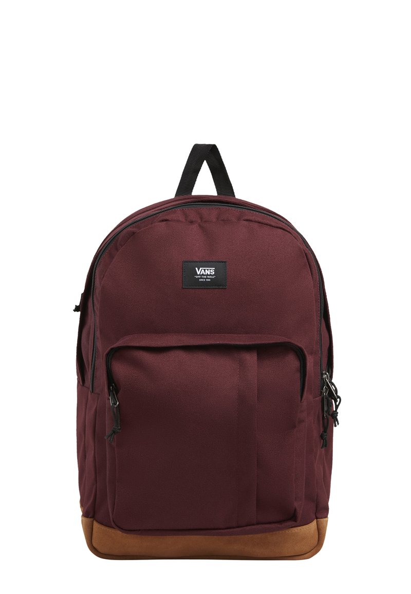 Mochila marrón con un fondo marrón, que cuenta con un compartimento principal con cremallera, un bolsillo frontal y herrajes negros. Hecha de un tejido duradero.