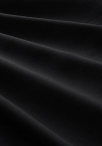 Čierny elastický materiál s hladkou textúrou, s jemnými záhybmi a mierne lesklým povrchom. Odolný a veľmi všestranný materiál.