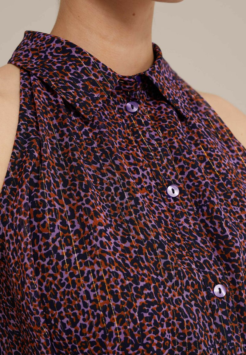 Ärmelloses Leopardenmusterhemd mit lila Kragen, lila Knöpfen und plissierter Textur; die Farben umfassen Schwarz, Orange und Lila.