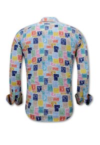 Langärmelig shirt met een kleurrijk postzegelpatroon met diverse portretten en ontwerpen op een witte achtergrond.