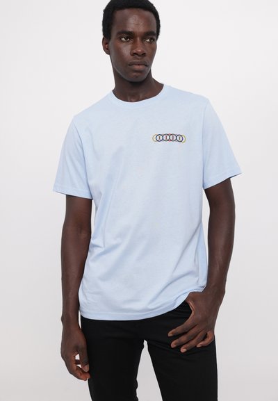 Lyseblå bomulds-t-shirt med korte ærmer, der har et multicolorer cirkulært grafik på brystet. Glat tekstur og afslappet pasform.
