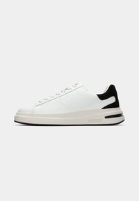 Sneakers bianchi in pelle con accentitura nera sul tallone, caratterizzati da una punta arrotondata, suola piatta e chiusura con lacci. Logo stampato sul lato.