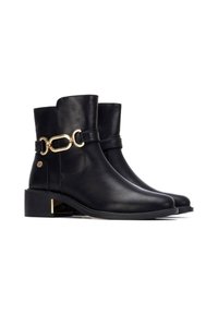 Botas de tobillo de cuero negro con un acabado suave, que cuentan con un acento de cadena dorada y un tacón bajo en bloque con un detalle metálico.