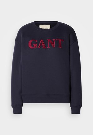 Navy blue sweatshirt in cotton blend, featuring raised red embroidered "GANT" logo across the chest. Ribbed cuffs and hem.