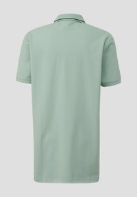 Jasnozielona koszulka polo z teksturowanej dzianiny, z krótkimi rękawami i kontrastowym ciemnym paskiem na kołnierzyku. Widok z tyłu.