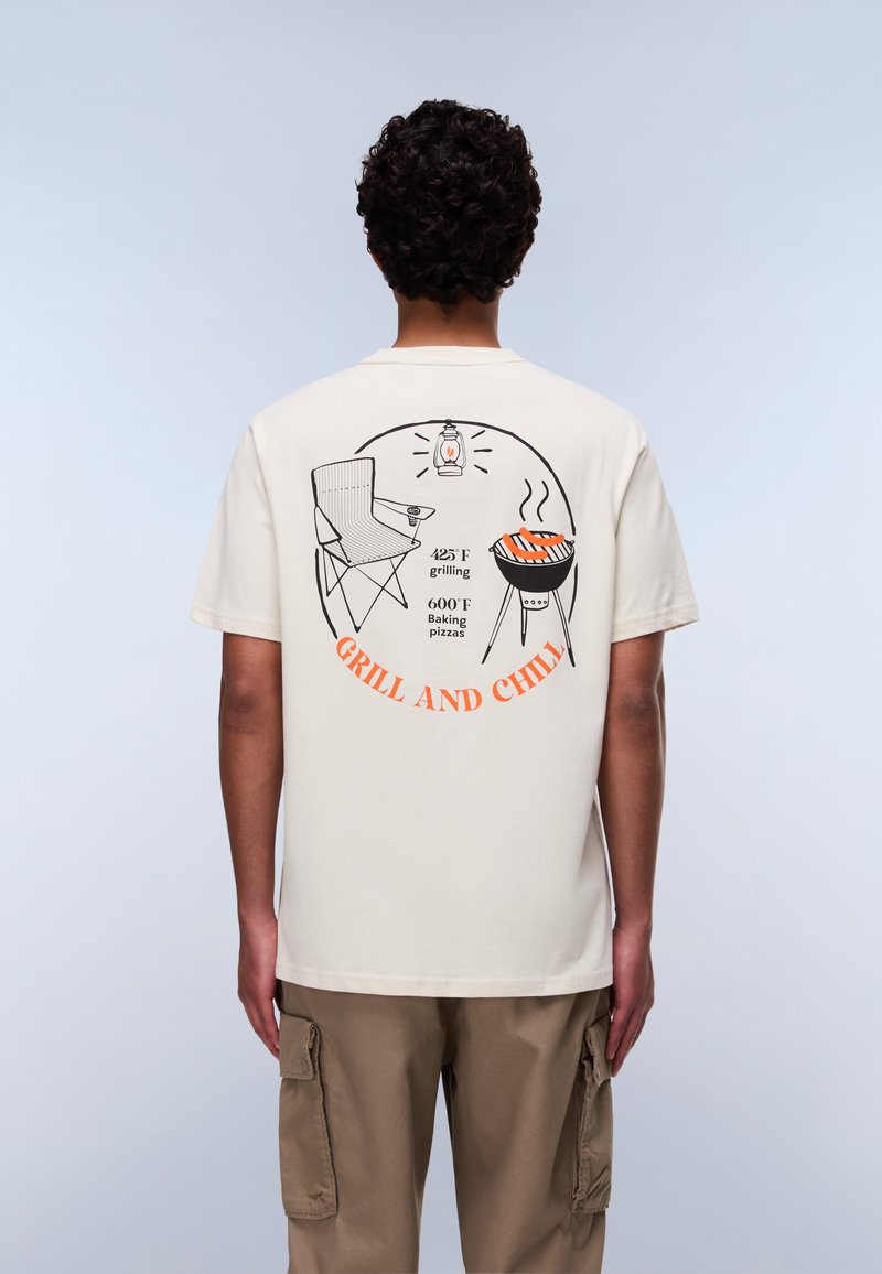 Beige Baumwoll-T-Shirt mit einem grafischen Druck auf der Rückseite, der ein Grill-Thema zeigt, einschließlich eines Stuhls, eines Grills und orangefarbener Schrift.