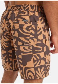 Hnědé a béžové plavky s geometrickým tropickým potiskem. Mají elastický pás a zadní kapsu se zapínáním na knoflík.