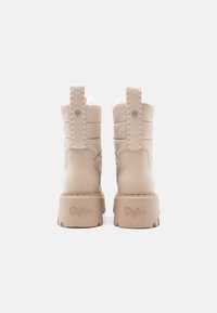 Ζευγάρι μπεζ χειμωνιάτικες μπότες Buffalo με επένδυση και λαβές, εμφανιζόμενο από πίσω σε λευκό φόντο.