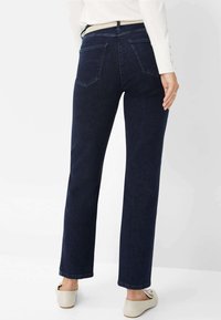 Jeans rectos de color azul oscuro con dos bolsillos traseros, una cinturilla y un dobladillo liso. El material parece suave con una textura mínima.