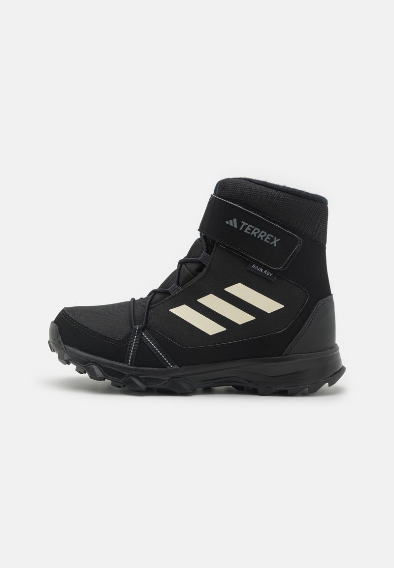 Black mid-cut hiking boot with a suede and mesh upper, featuring three white stripes on the side, adjustable strap, and textured rubber sole.