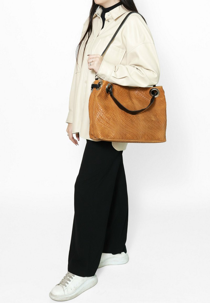 Borsa a tracolla in pelle intrecciata marrone con finitura testurizzata, dotata di accessori circolari neri e di una tracolla rimovibile.