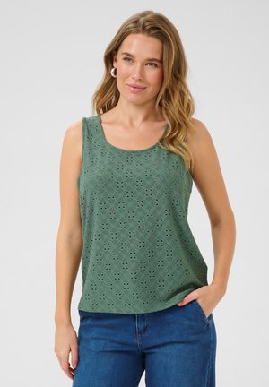 Groene, mouwloze tanktop met een bloemenlaser-cut patroon, ronde halslijn en zachte textuur. Gepaarde met blauwe spijkerbroek.