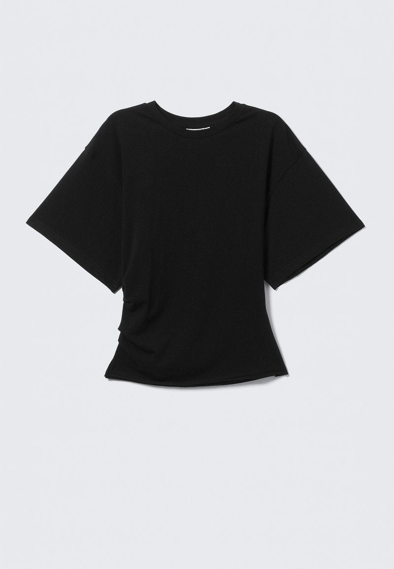 Μαύρο T-shirt με κοντό μανίκι και στρογγυλή λαιμόκοψη, με ελαφρώς φαρδύ χαλαρό κόψιμο, εμφανίζεται σε ανοιχτό γκρι φόντο.