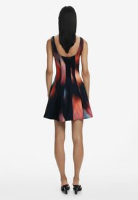 Fit-and-flare dress in a multicolored abstract pattern with a scooped back, made of a smooth, stretchy fabric. Knee-length hem.