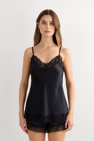 Sort satin camisole med justerbare spaghetti-stropper, der har en delikat blondekant langs udskæringen og kanten, suppleret med matchende shorts.
