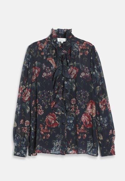 Blouse florale foncée à manches longues, devant et col volantés, avec des motifs de fleurs rouges, bleues et vertes sur fond bleu marine.