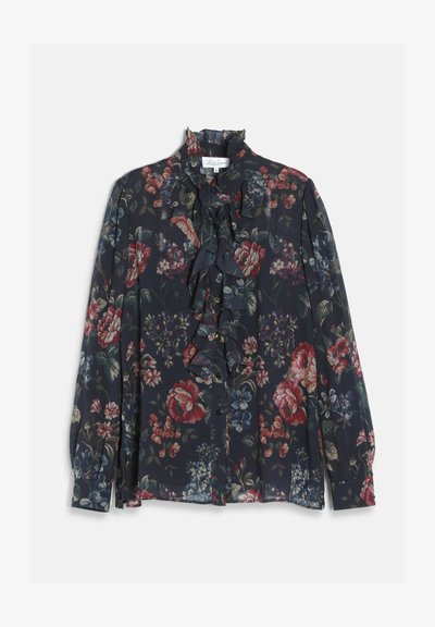 Blouse florale foncée à manches longues, devant et col volantés, avec des motifs de fleurs rouges, bleues et vertes sur fond bleu marine.