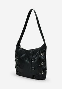 Borsa in pelle nera con una forma morbida, caratterizzata da accessori in metallo argentato e dettagli con fibbia sui lati. Inclusa una tracolla regolabile.