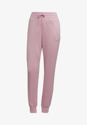 Jasnoróżowe spodnie dresowe Adidas z elastycznym pasem, sznurkiem, ściągaczami przy kostkach i małym białym logo Adidas na prawej udzie.