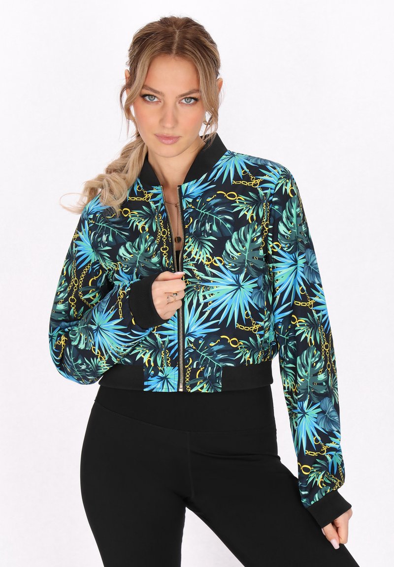 Korte bomberjack met een levendige tropische bladerenprint in tinten blauw en groen, voorzien van gouden kettingaccenten en zwarte ribgebreide afwerking.