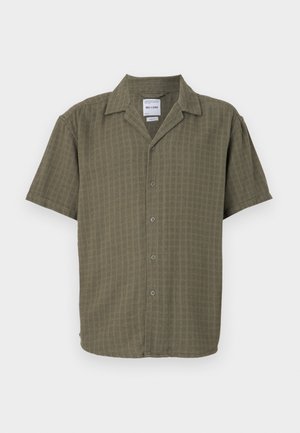 Chemise à manches courtes en vert olive, avec un motif texturé, un devant boutonné et un col classique. Fabriquée en tissu doux et respirant.