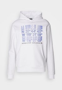 Bílá mikina s klokaní kapsou na přední straně, která má modré potištěné souřadnice a text "NEVER STOP EXPLORING" v černé barvě. Materiál z bavlněné směsi.