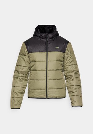 Chaqueta de plumas con una sección superior negra y una sección inferior verde oliva. Cuenta con una capucha, cierre de cremallera en el frente y un pequeño logo en el pecho.